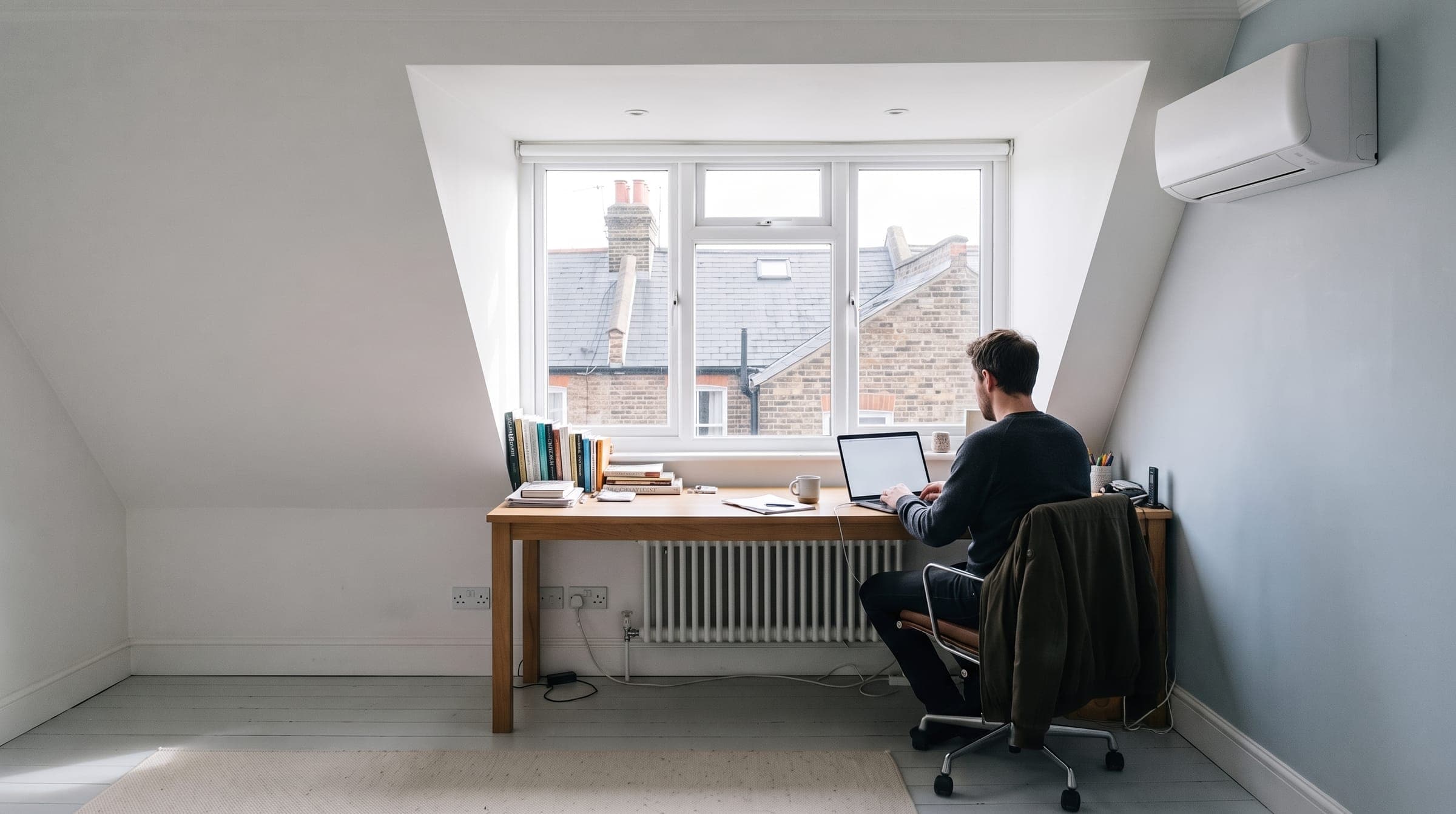 Rear dormer loft conversion used as a study, with a slim white air conditioning unit high on the wall