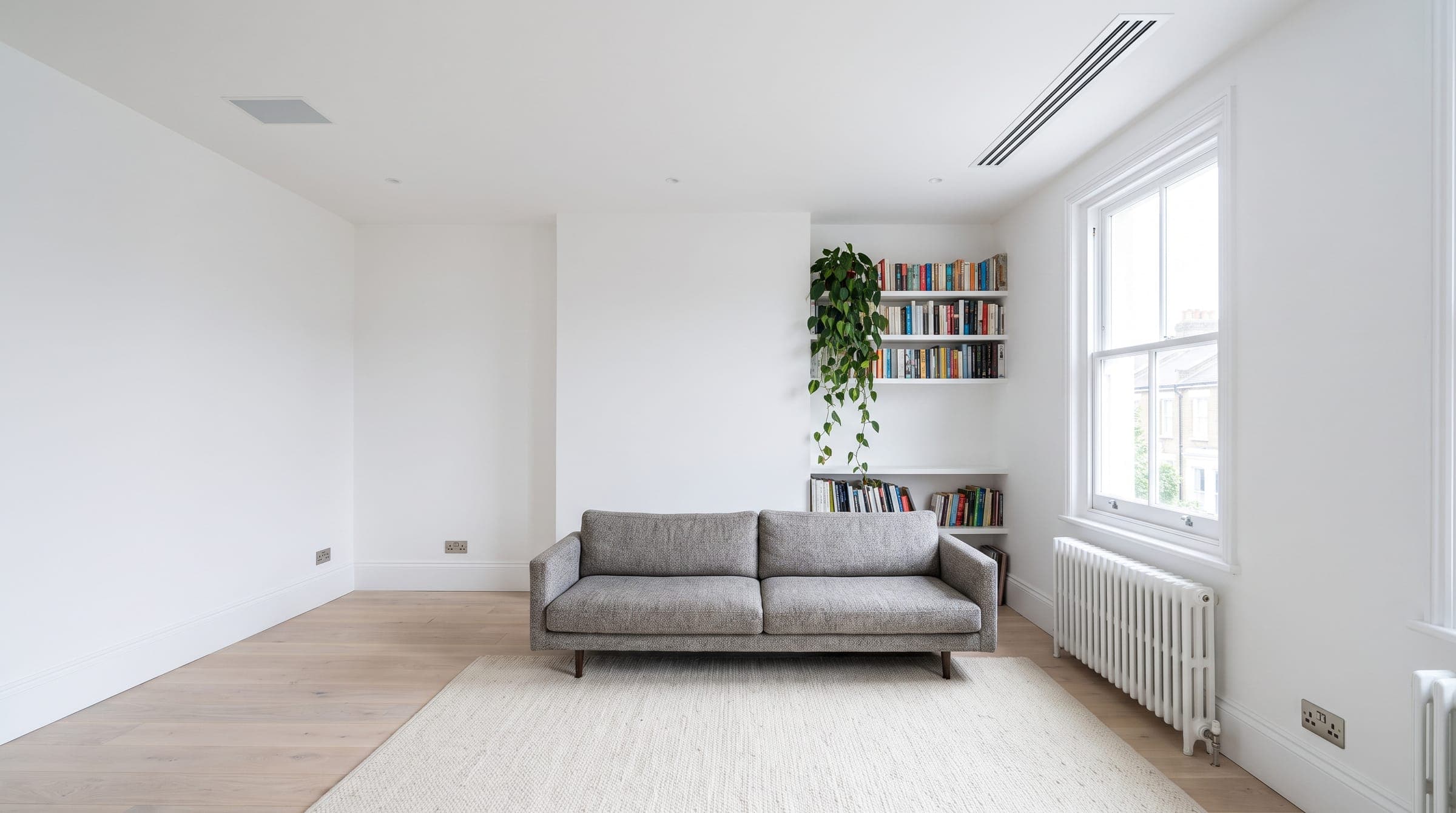 Bright Victorian living room with a slim linear air grille set flush in the ceiling and no visible indoor unit