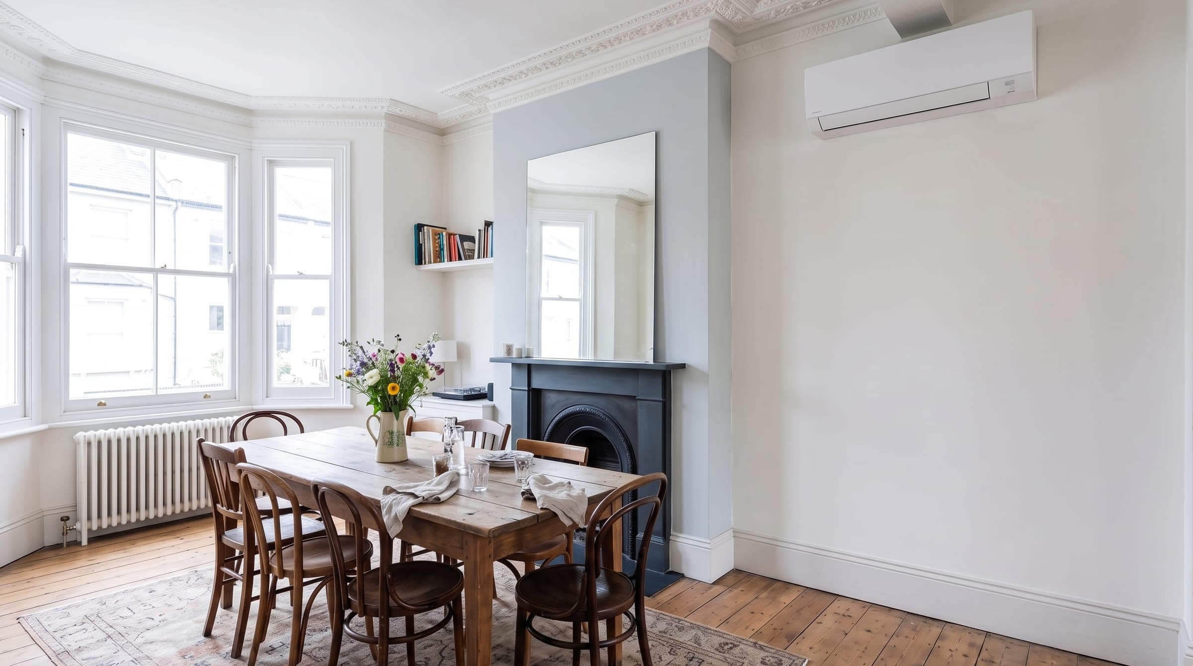 Slim white wall-mounted air conditioning unit above a sideboard in a Victorian dining room