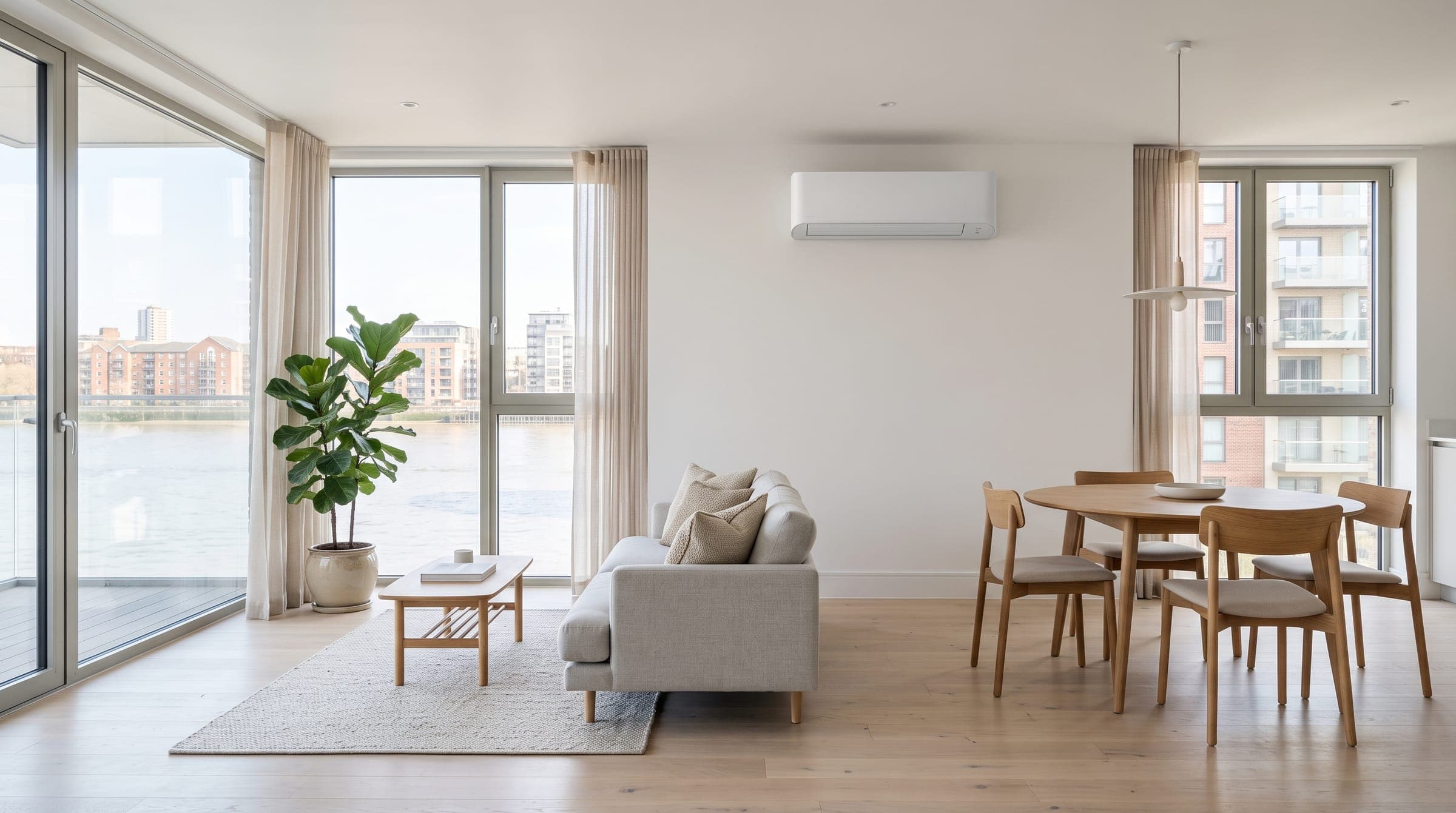 Open-plan riverside flat in London with a white air conditioning unit on the living room wall